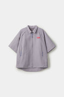 Grey checkered shirt with a red logo and red details in the zipper
