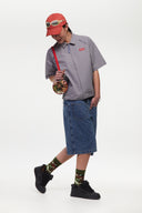 Grey checkered shirt with a red logo and red details in the zipper
